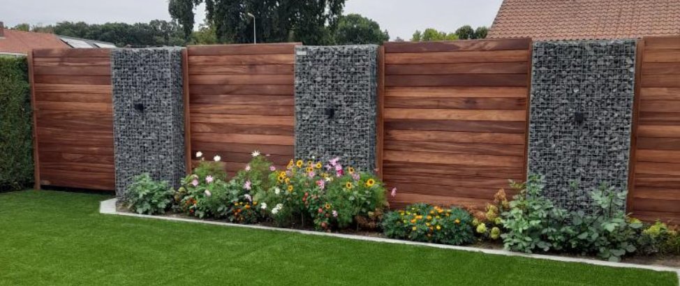 Zaun aus Holzelementen kombiniert mit Gabionen